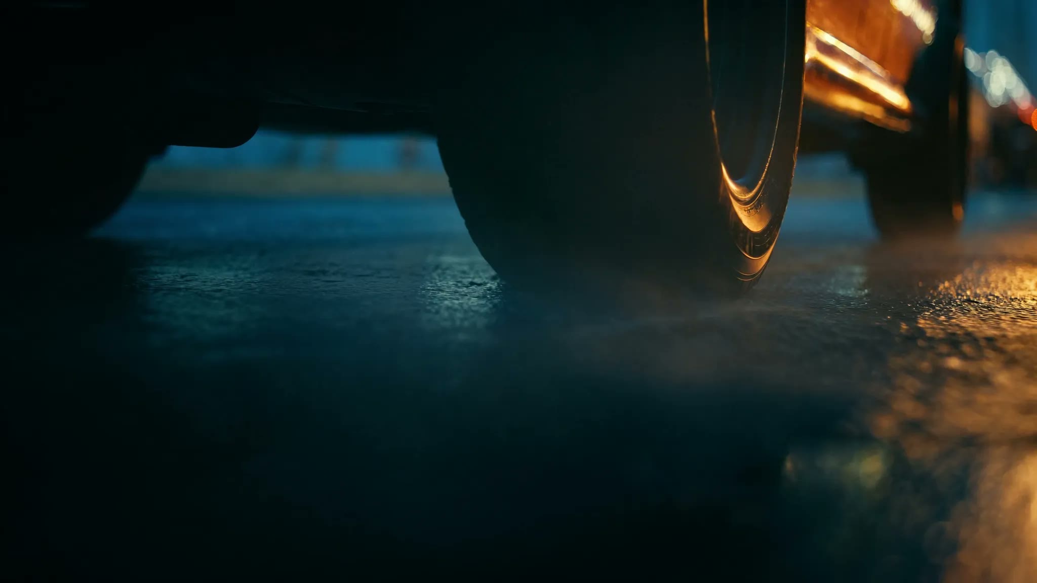 Tire rolling on wet asphalt at dusk